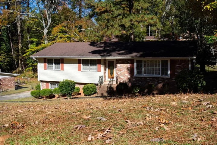 Brick and siding exterior with a dark shingle roof