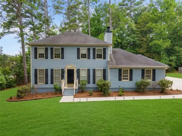 Light blue siding exterior with black shutters, white trim, and a prominent front entrance