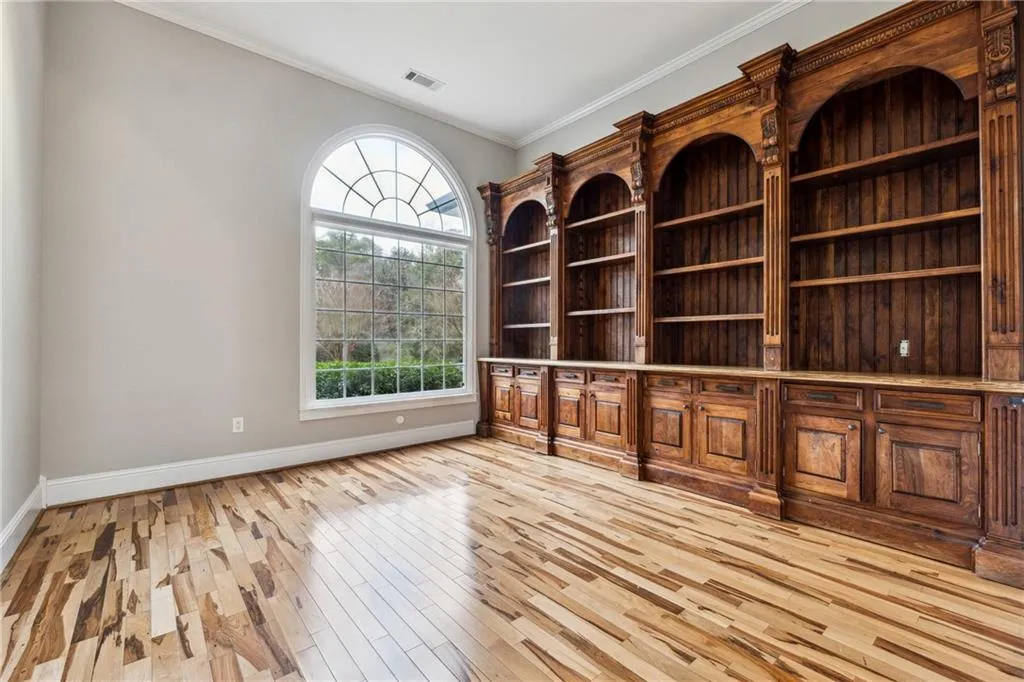 Unfurnished office with ornamental molding and light wood-type flooring