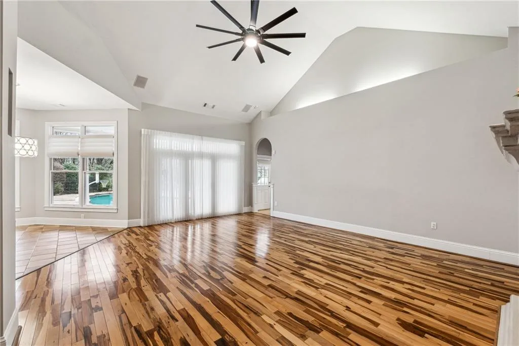 Unfurnished living room with high vaulted ceiling, light hardwood / wood-style floors, and ceiling fan