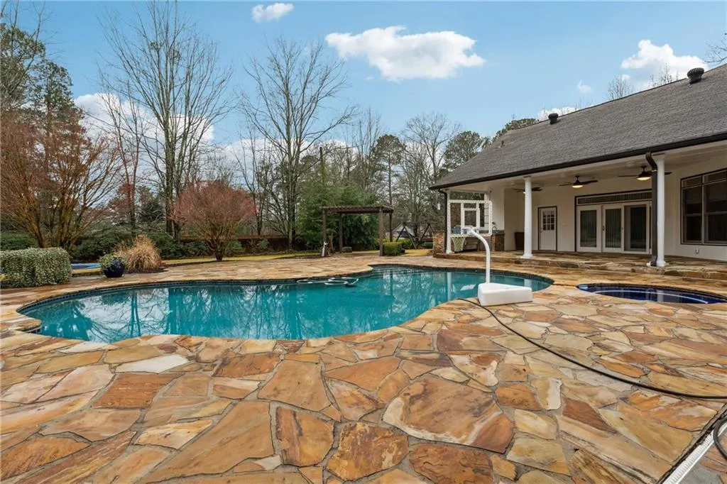 View of pool with french doors, ceiling fan, a pergola, and a patio area