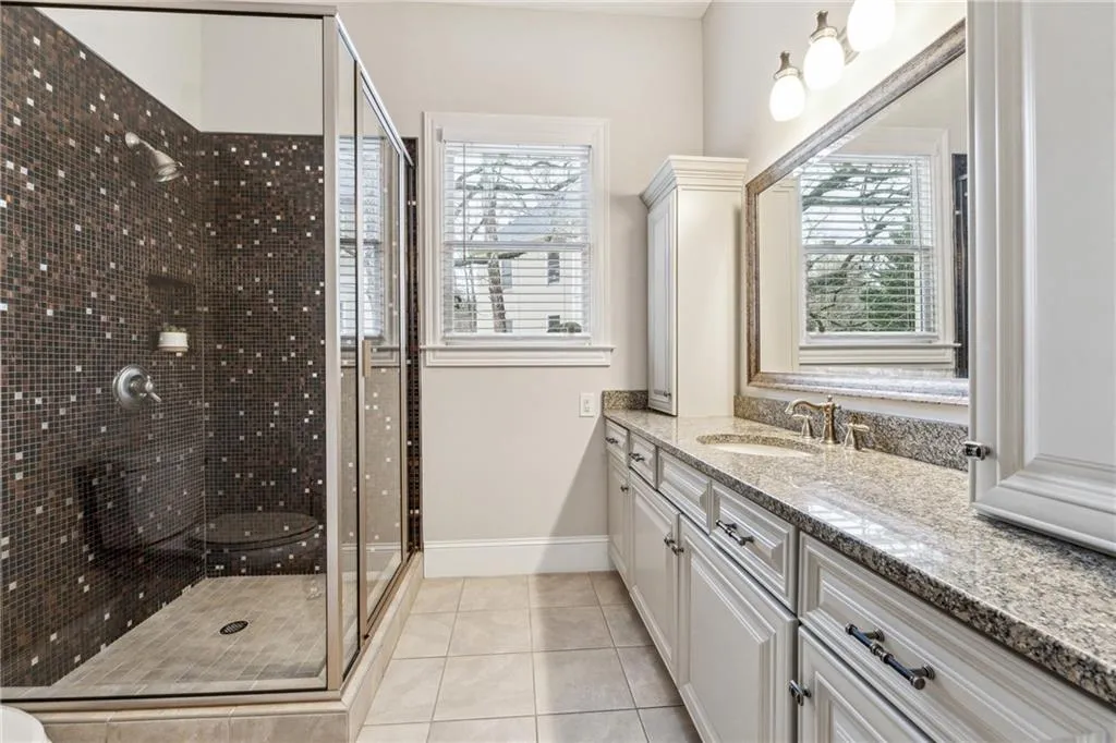 Bathroom featuring tile patterned floors, an enclosed shower, and vanity