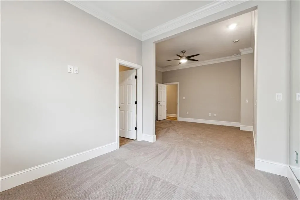Unfurnished room featuring ornamental molding, light carpet, and ceiling fan