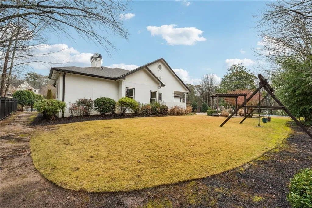Rear view of house with a pergola and a lawn