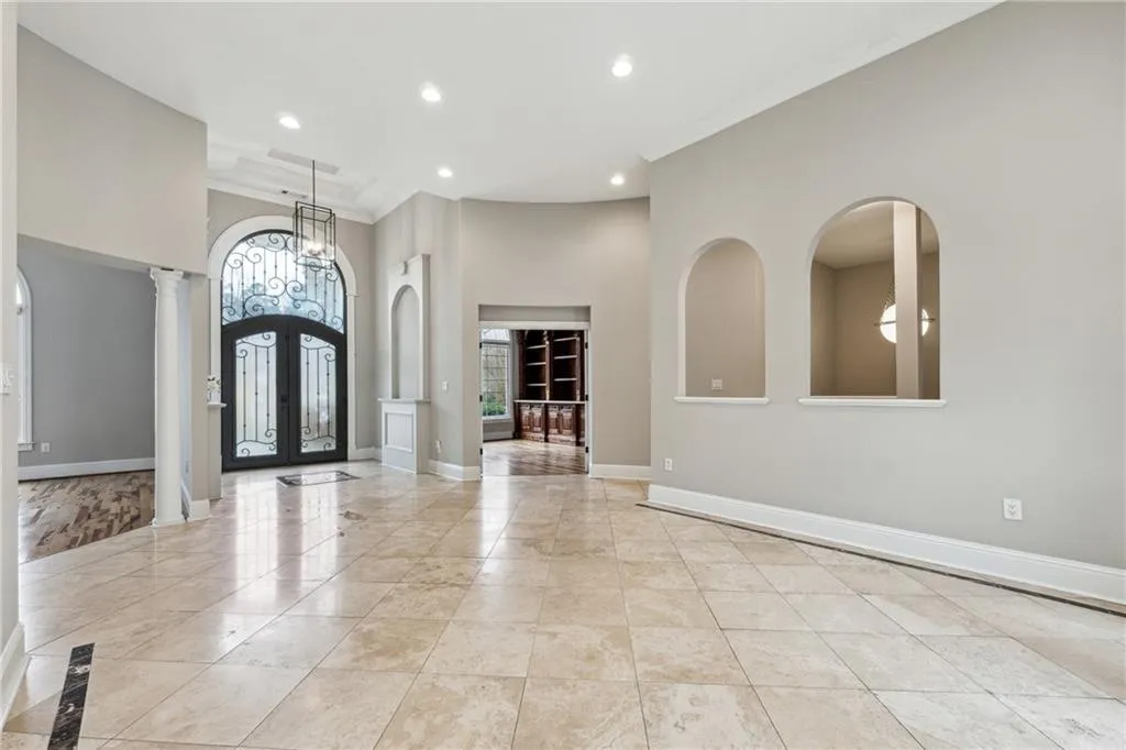 Entrance foyer featuring a high ceiling, crown molding, a wealth of natural light, and french doors