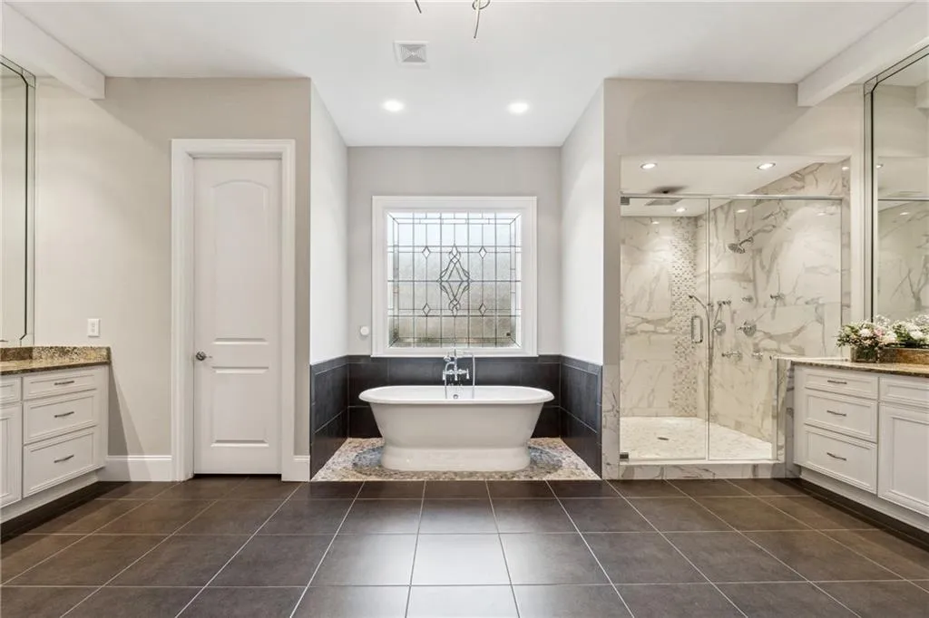 Bathroom with tile patterned floors, vanity, and shower with separate bathtub