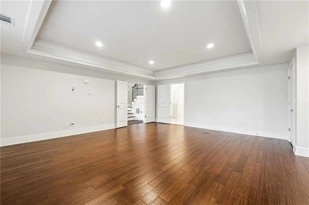 Unfurnished living room with dark hardwood / wood-style flooring and a raised ceiling