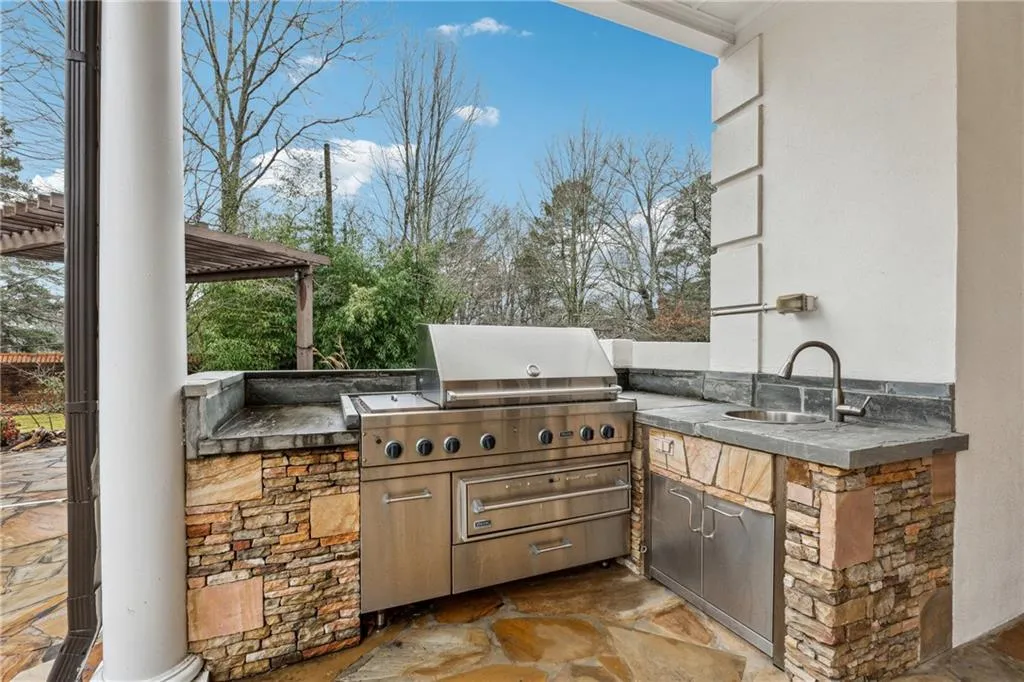 View of patio featuring an outdoor kitchen and sink
