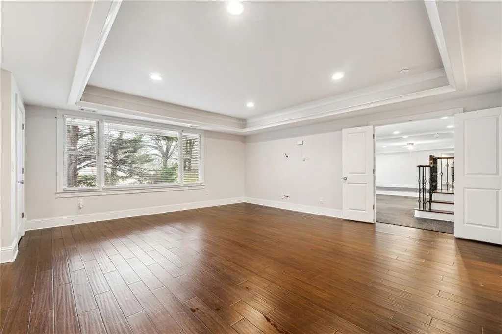 Unfurnished living room with dark hardwood / wood-style floors and a tray ceiling