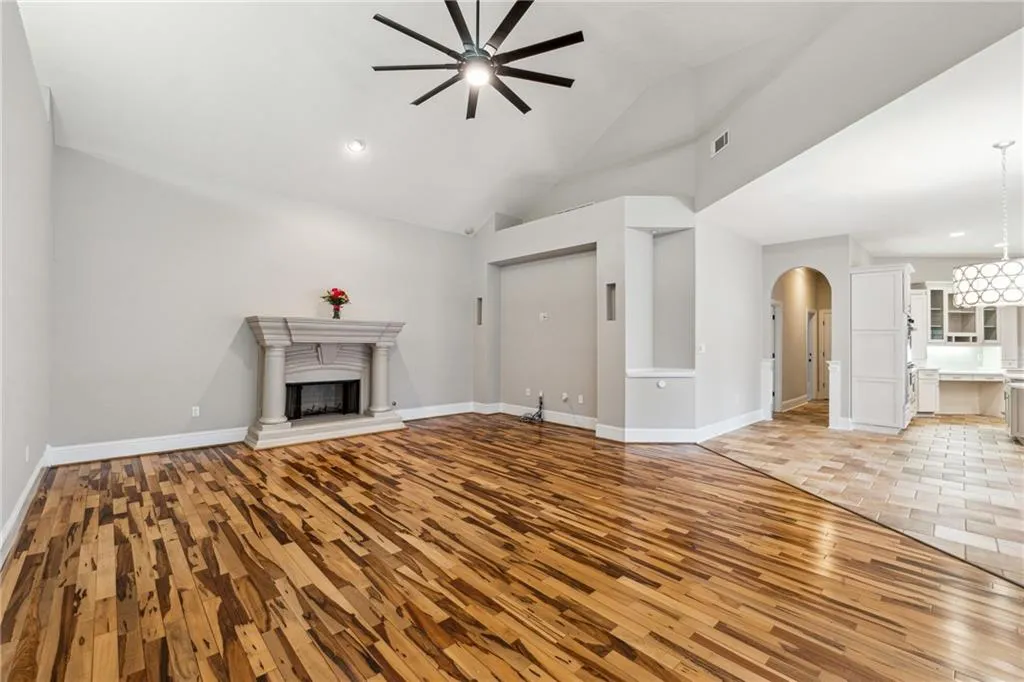 Unfurnished living room with ceiling fan, high vaulted ceiling, and light hardwood / wood-style floors
