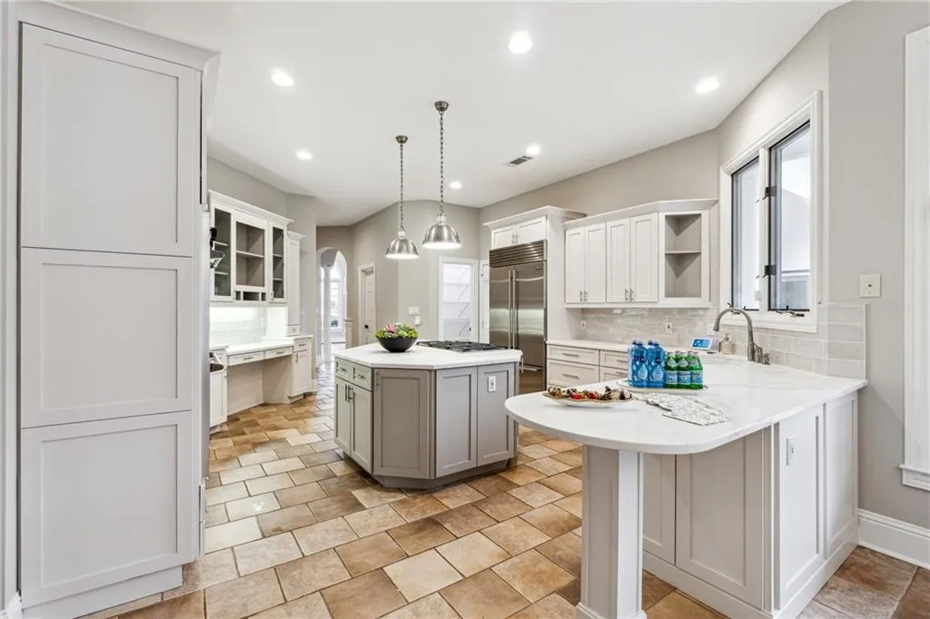 Kitchen featuring tasteful backsplash, decorative light fixtures, stainless steel appliances, and a kitchen island