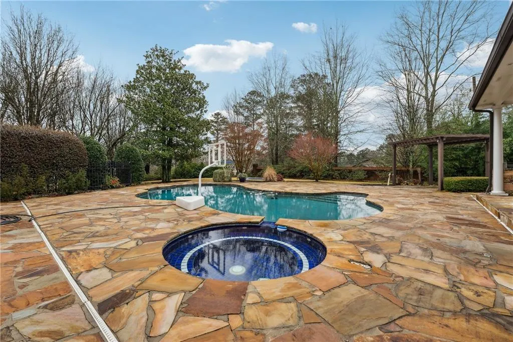 View of pool featuring a pergola, a patio area, and an in ground hot tub
