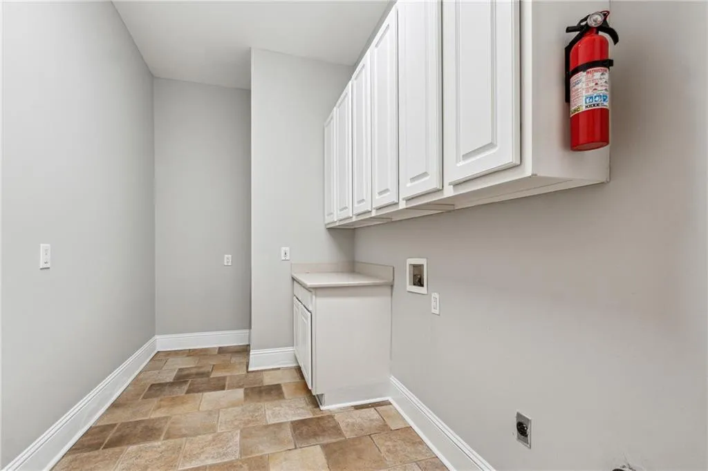 Clothes washing area with cabinets, washer hookup, and electric dryer hookup