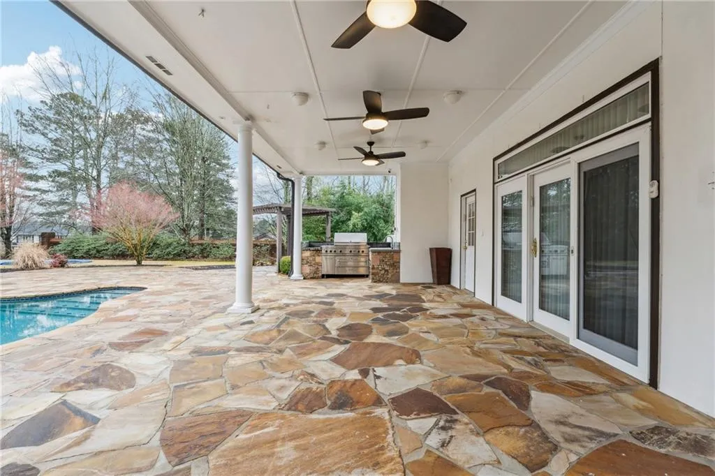 View of patio with an outdoor kitchen, a grill, and ceiling fan