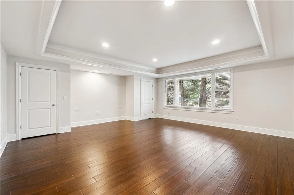 Spare room with dark hardwood / wood-style floors and a raised ceiling