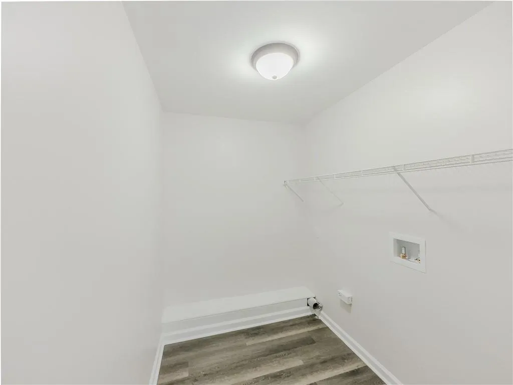 Laundry room featuring baseboards, hookup for a washing machine, laundry area, and wood finished floors