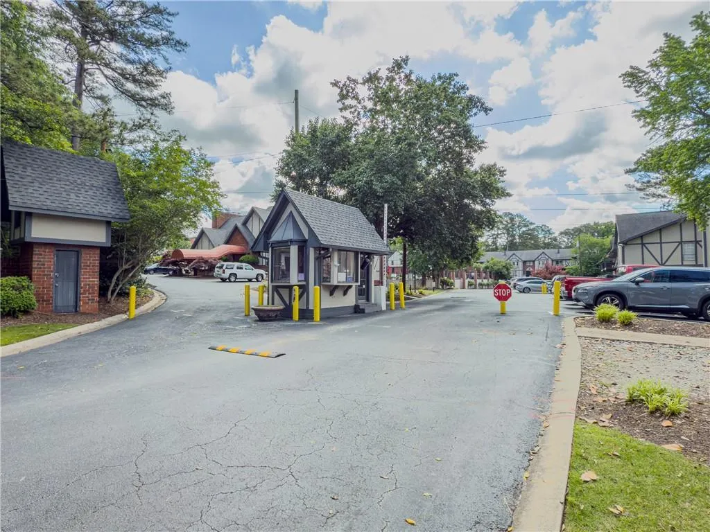 View of road with traffic signs, curbs, and a gated entry