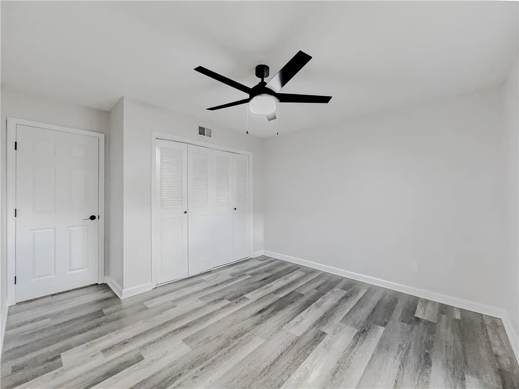 Unfurnished bedroom featuring baseboards, a closet, and wood finished floors