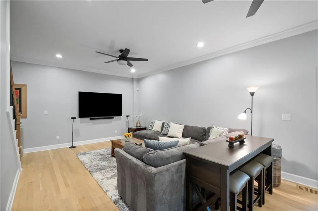 Living room featuring ceiling fan, ornamental molding, recessed lighting, and light wood-style floors