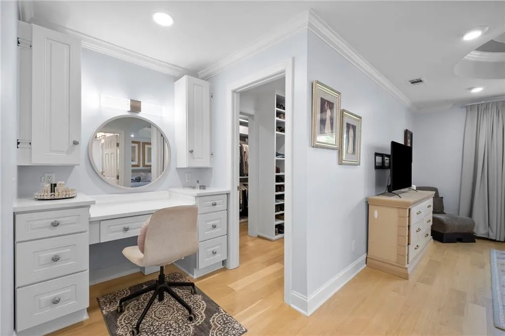 Bathroom featuring vanity, crown molding, recessed lighting, a walk in closet, and light wood-style floors