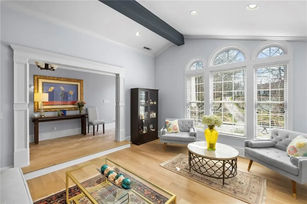 Living area featuring light wood-style flooring, lofted ceiling with beams, and recessed lighting