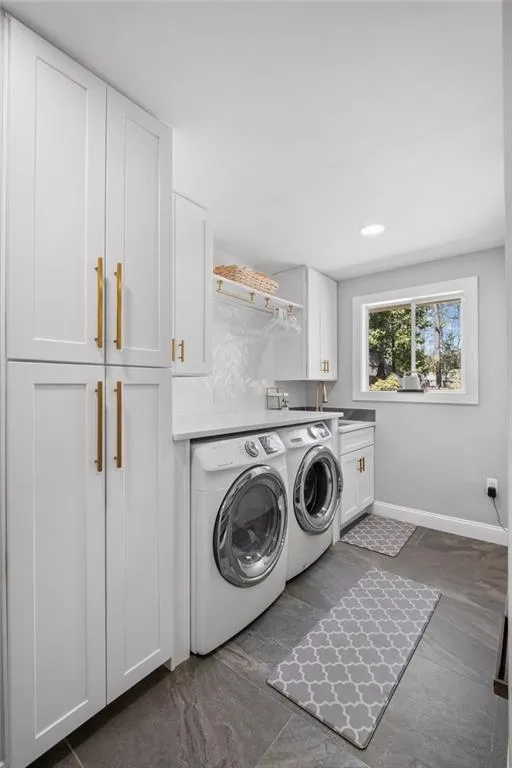 Laundry room featuring cabinet space, independent washer and dryer, and recessed lighting