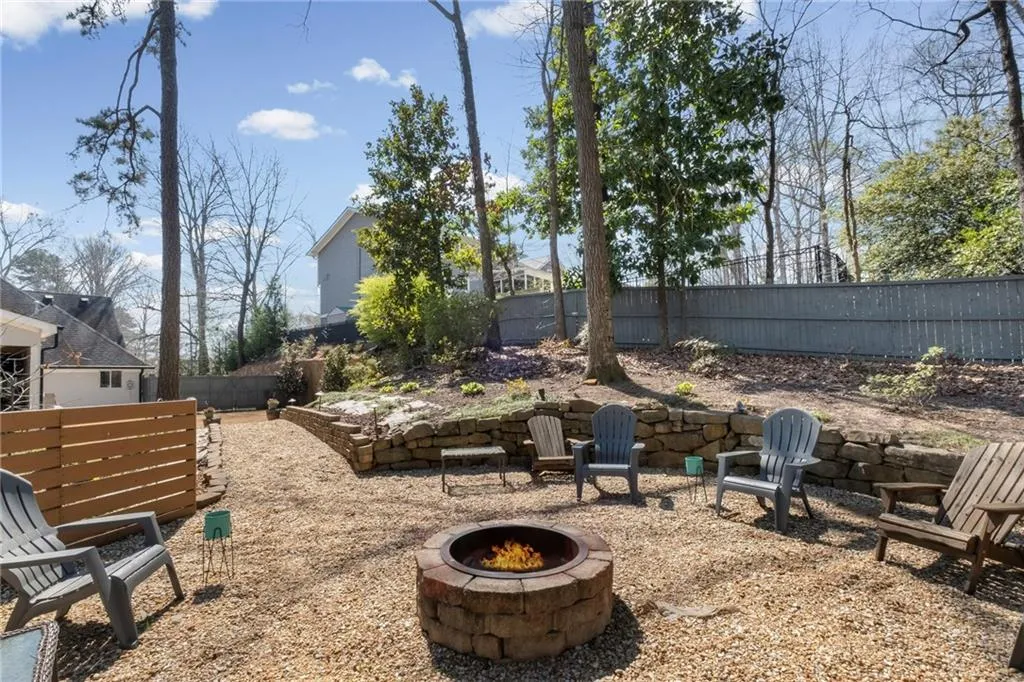 Fenced backyard with an outdoor fire pit and a patio area