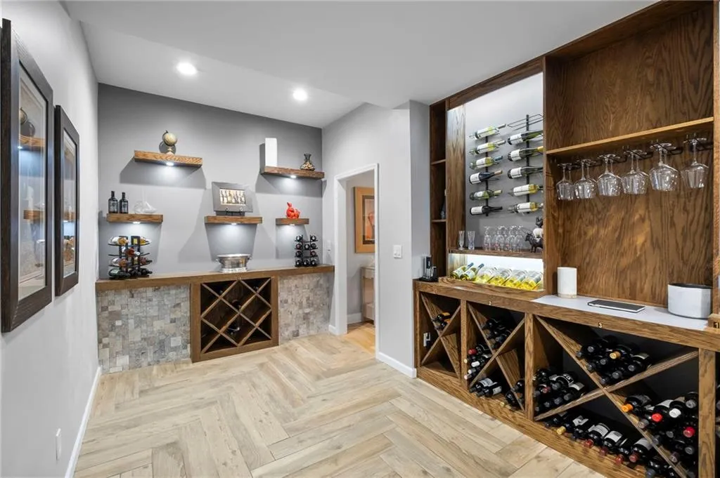 Wine room featuring parquet flooring, recessed lighting, and a bar