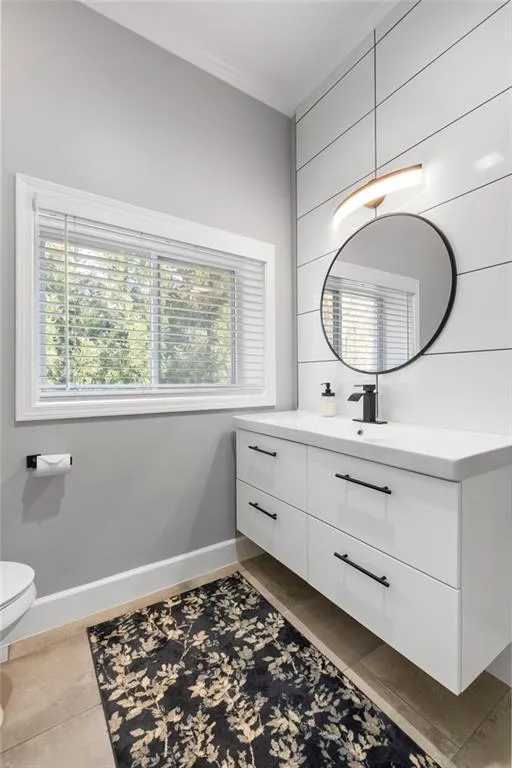 Bathroom featuring vanity, dark tile patterned floors, and ornamental molding