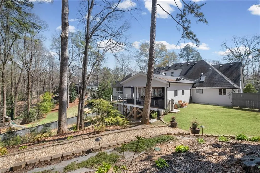 Back of house with a wooden deck, stucco siding, and a shingled roof
