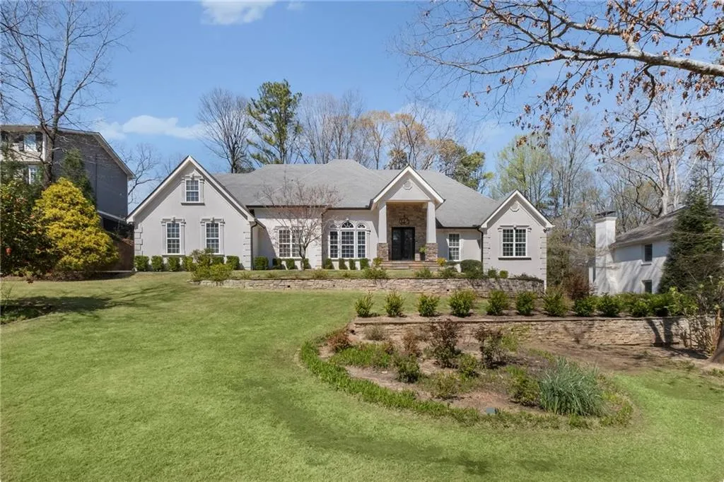 View of front of home with a front lawn and stone siding