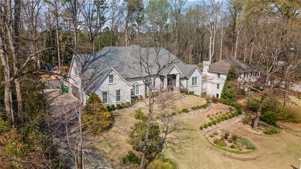 View of front of house with a chimney and stucco siding