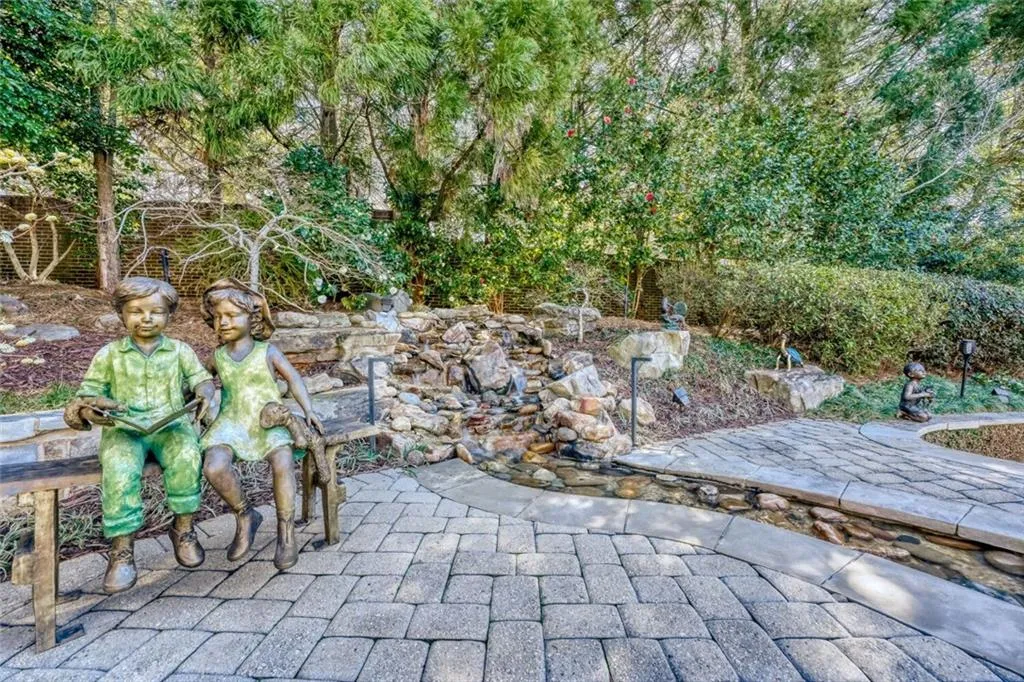 Stone waterfall has a branch that empties into the pool.