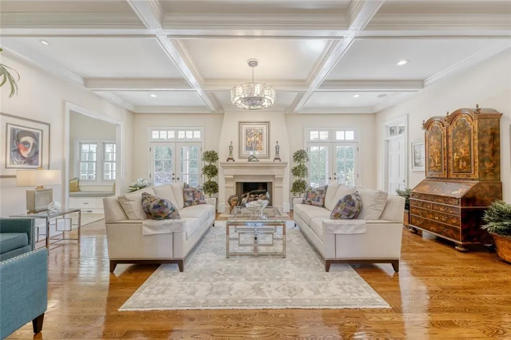 Inviting living room boasts limestone fireplace and coffered ceilings.