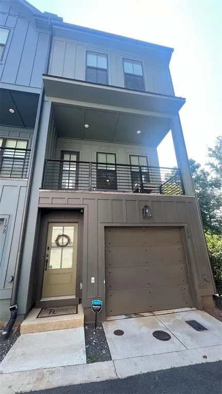 Entrance to property featuring board and batten siding and concrete driveway