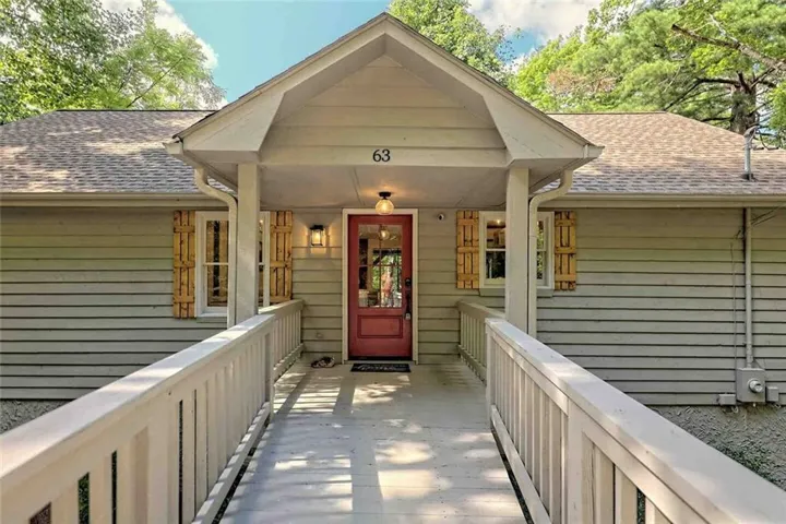 Front exterior featuring a covered entry, gabled roofline, and a prominent red entry door