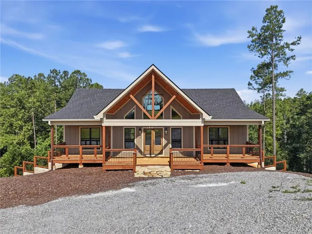 Craftsman-style exterior with wood siding, a gabled roof, and an expansive wooden deck with railing