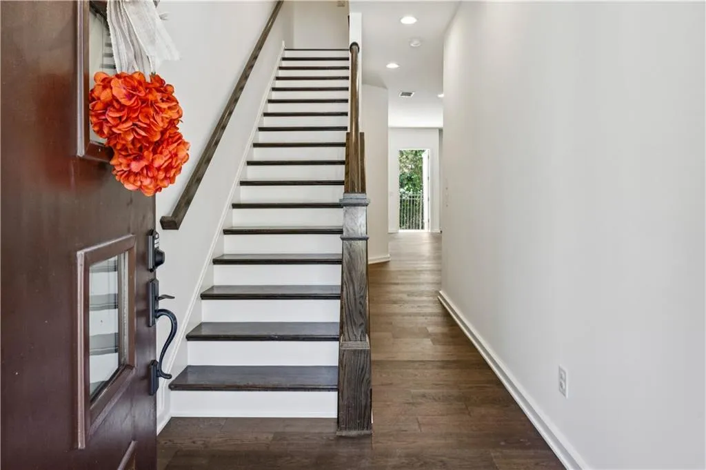 Stairway featuring wood finished floors and recessed lighting
