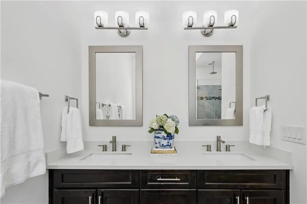 Full bath with a shower stall and double vanity