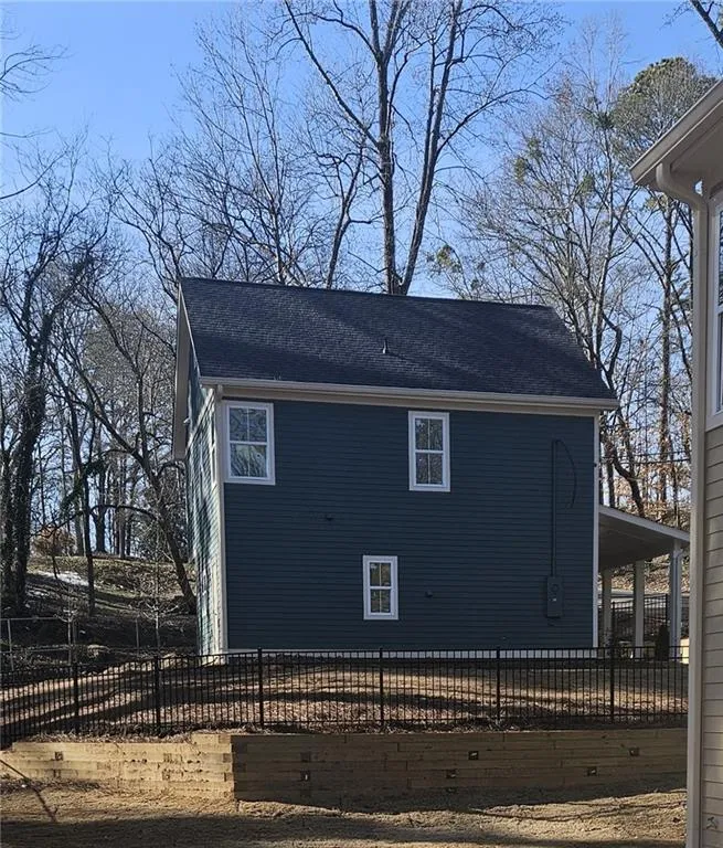 View of side of property with roof with shingles