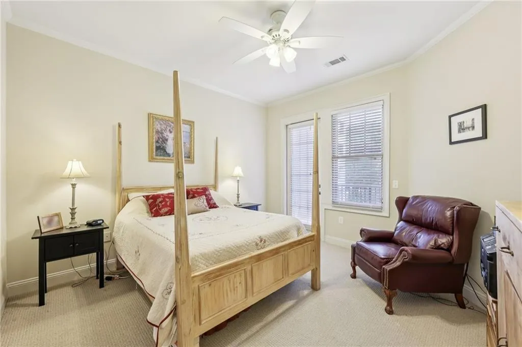 Bedroom featuring crown molding, light colored carpet, and a ceiling fan Bedroom featuring crown molding, light colored carpet, and a ceiling fan