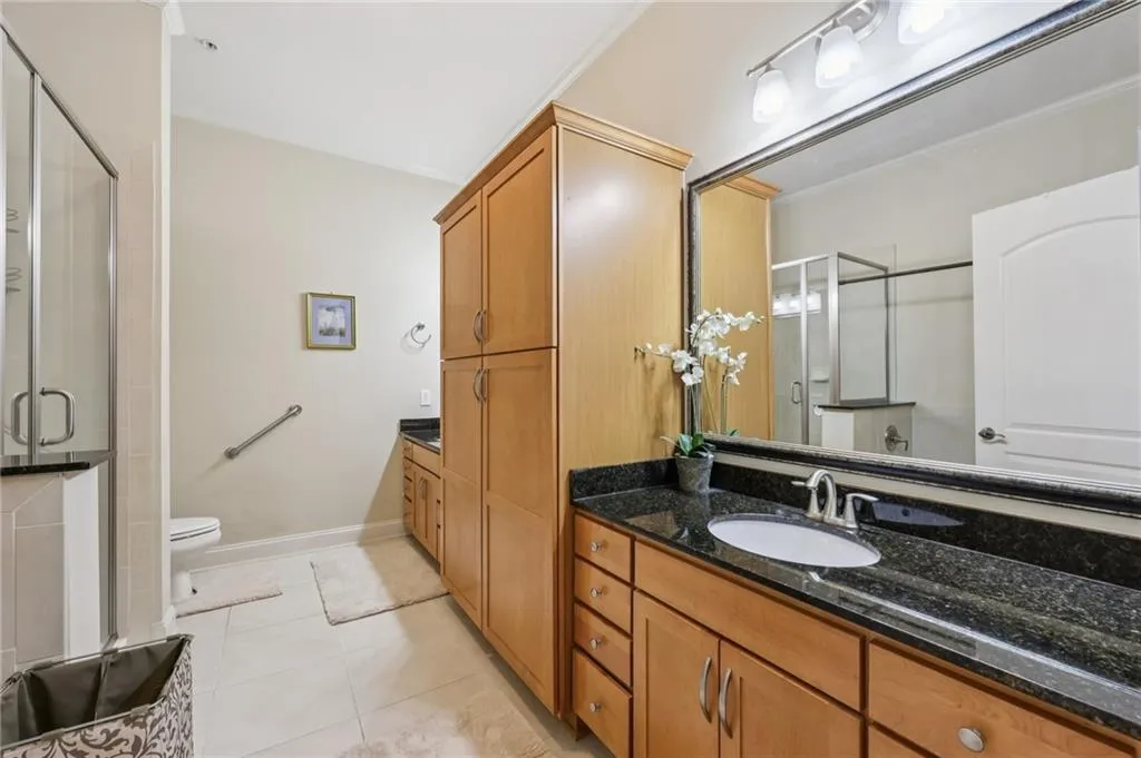 Bathroom with vanity, light tile patterned flooring, a shower stall, and crown molding Bathroom with vanity, light tile patterned flooring, a shower stall, and crown molding