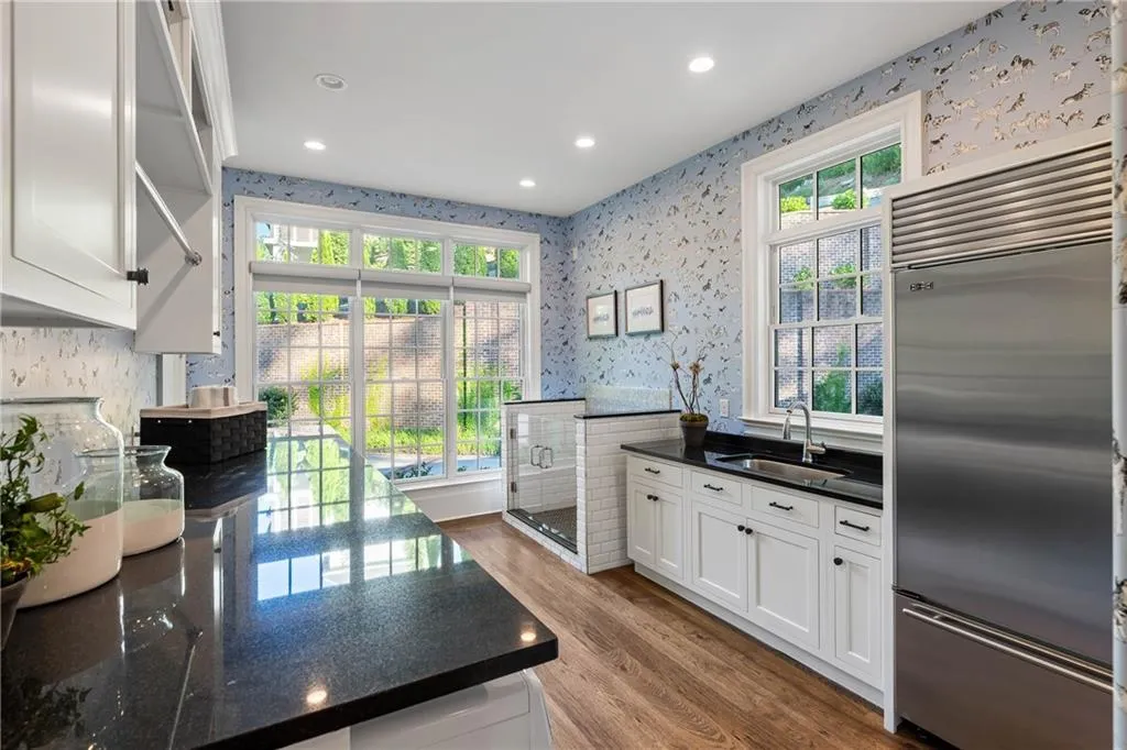 Laundry room with 2 washer, 2 dryers, a dog bath, refrigerator, sink and cabinets