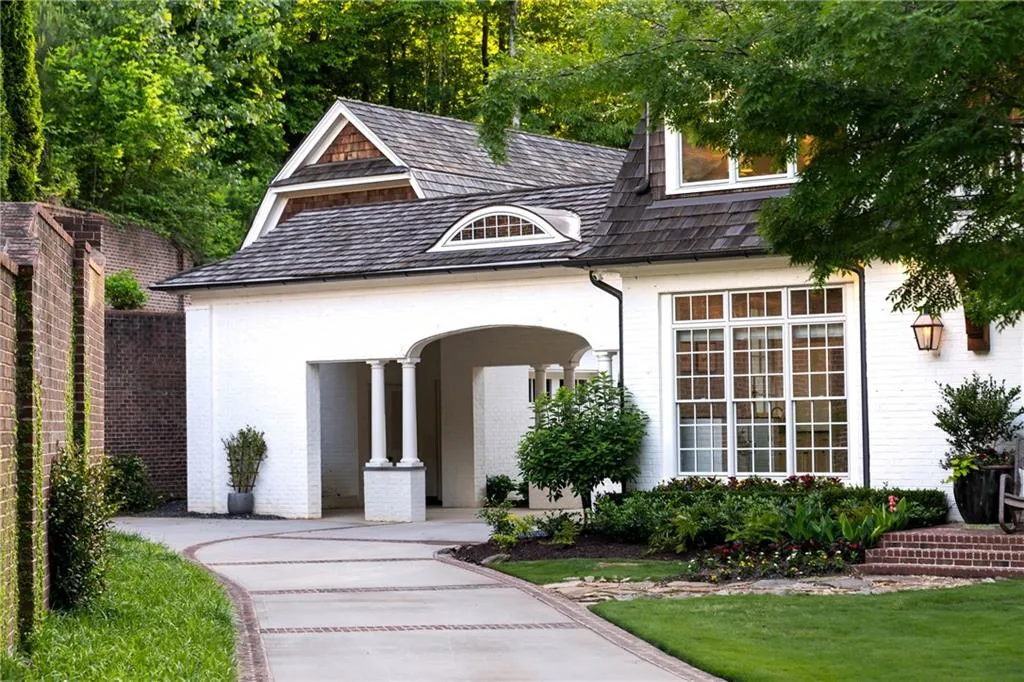 Through the porte cochere is a three-car garage with ample space above to convert to carriage home or studio