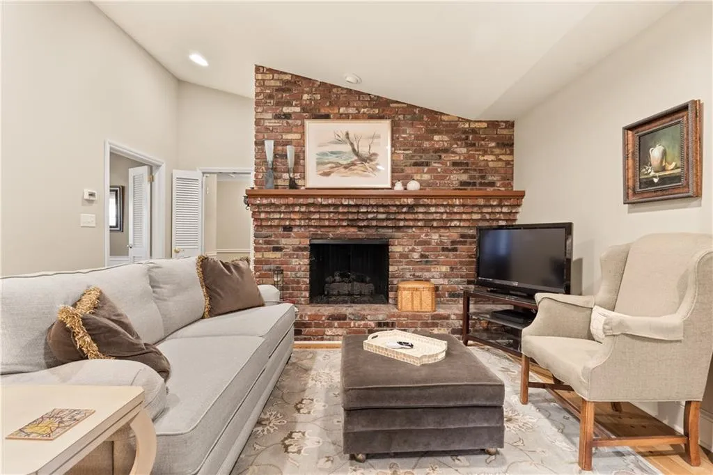 Living area featuring lofted ceiling, wood finished floors, and a fireplace