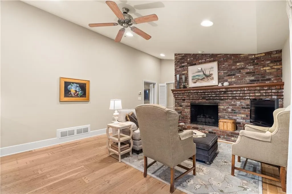 Living room with light wood-style flooring, recessed lighting, a fireplace, ceiling fan, and high vaulted ceiling