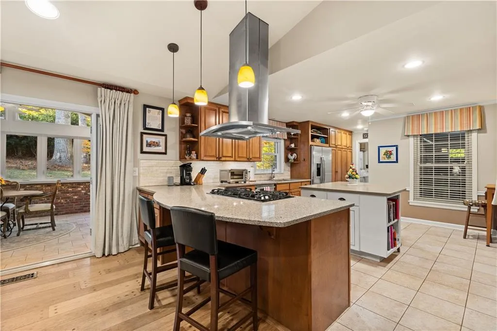 Kitchen with open shelves, recessed lighting, a breakfast bar, a kitchen island, and a peninsula