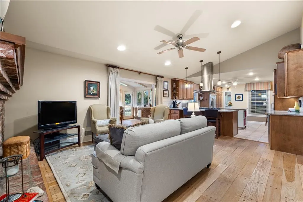 Living room with ceiling fan, recessed lighting, light wood-type flooring, and high vaulted ceiling