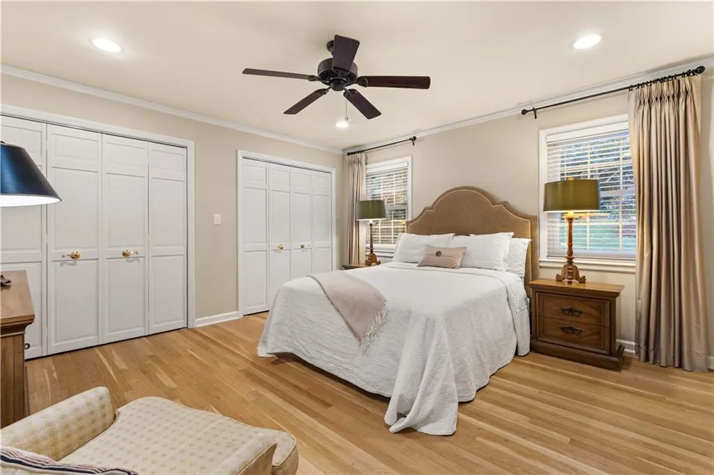 Bedroom with multiple closets, crown molding, light wood finished floors, a ceiling fan, and recessed lighting