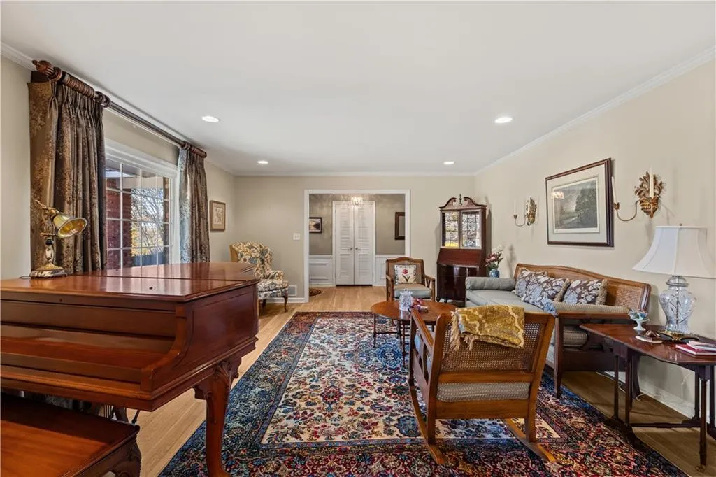 Living area featuring ornamental molding, light wood-style flooring, and recessed lighting